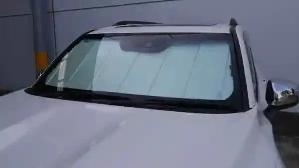 Car with a sunshade covering the windshield against a gray background