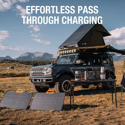 Black SUV with rooftop tent and solar panels in a mountainous landscape