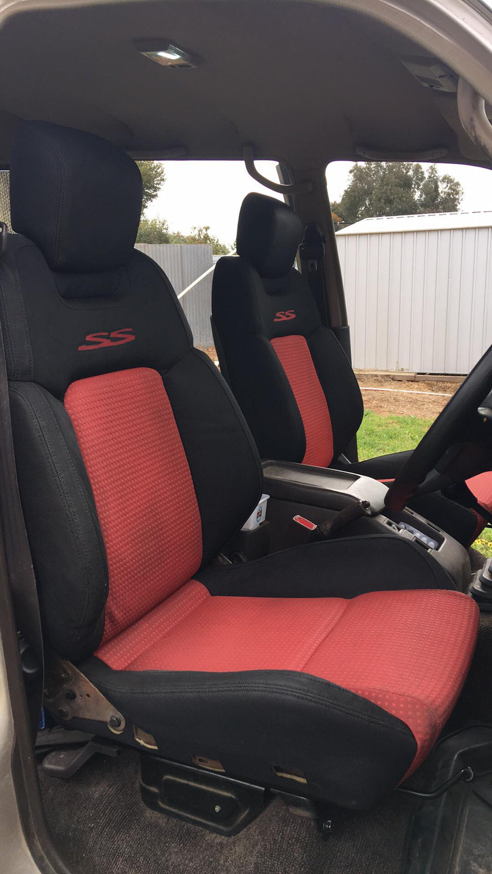 Red and black car seat covers with 'SS' logo inside a vehicle.
