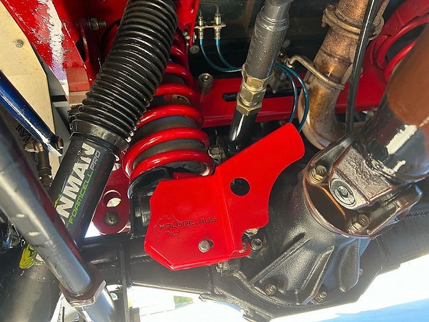 Close-up of a motorcycle suspension system with red components and visible branding.