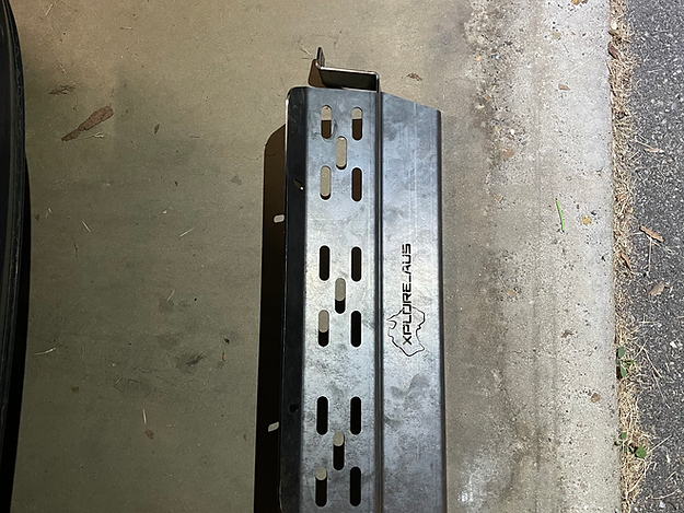 Metal Radiator Protector with 'xploreaus' branding on a concrete surface