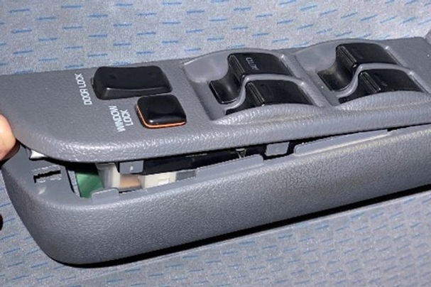 Car window control switch panel with multiple buttons on a gray background