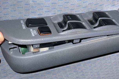 Car window control switch panel with multiple buttons on a gray background