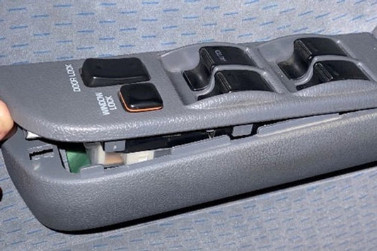 Car window control switch panel with multiple buttons on a gray background