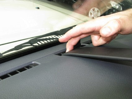 Person adjusting a car's dashboard panel