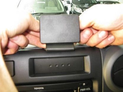 Person installing a car mount on a Toyota vehicle's dashboard.
