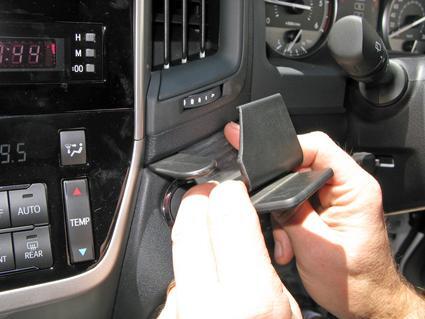Person installing a phone mount in a car's dashboard.