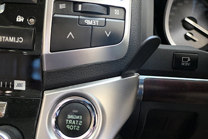 Car interior with climate control panel and start-stop button.