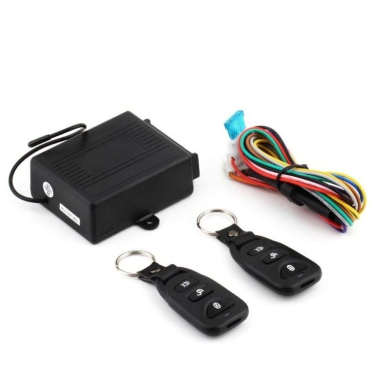 Car alarm system with black control box, two key fobs, and wiring harness on a white background