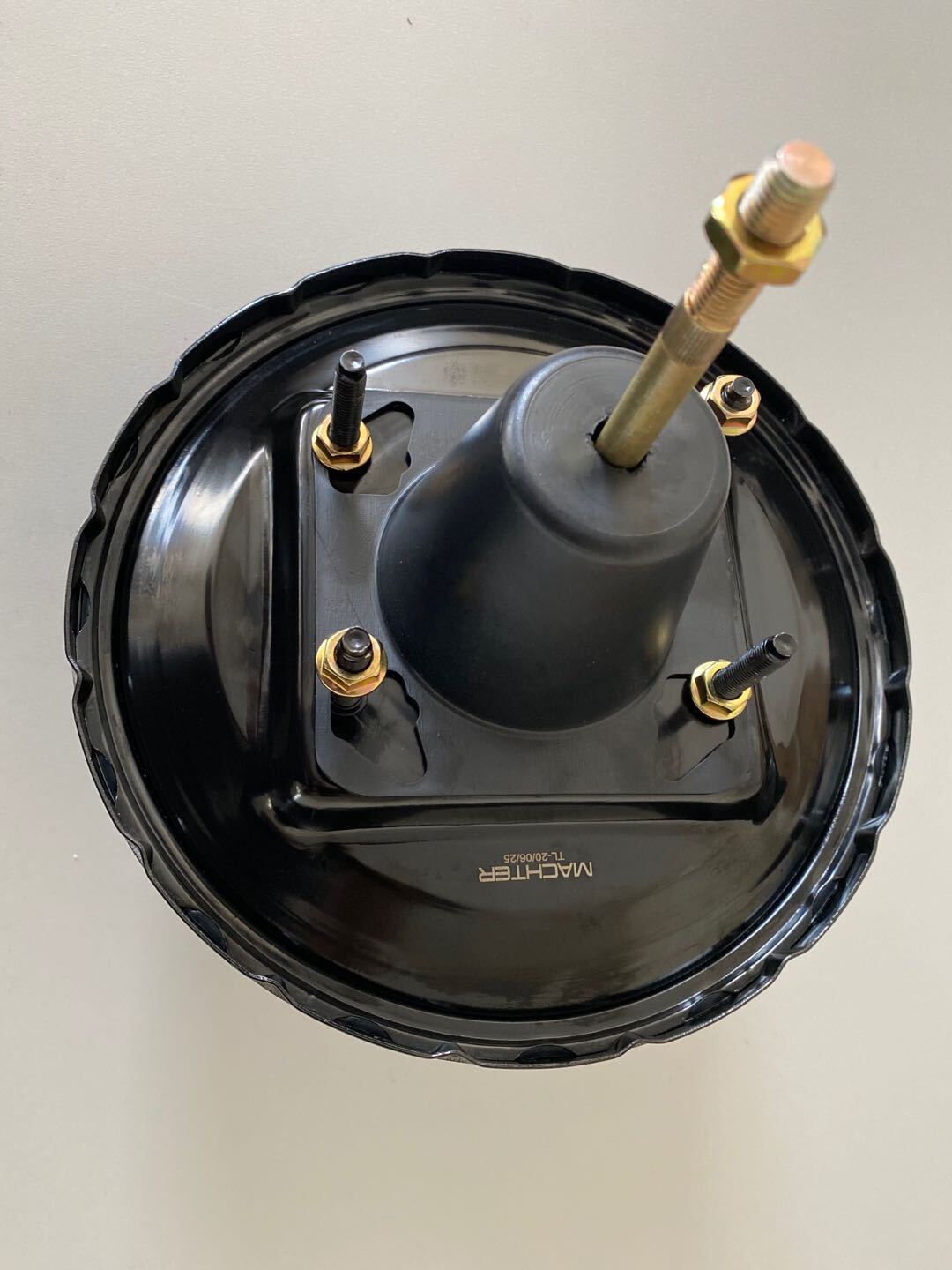 Black Power Brake Booster with gold bolts on a light gray background