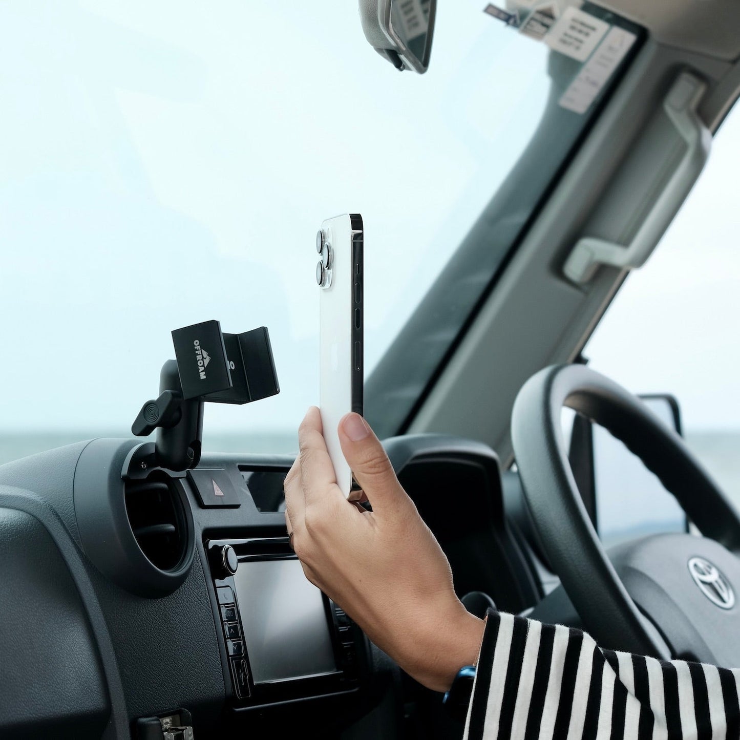 Person using a smartphone with a car mount inside a vehicle