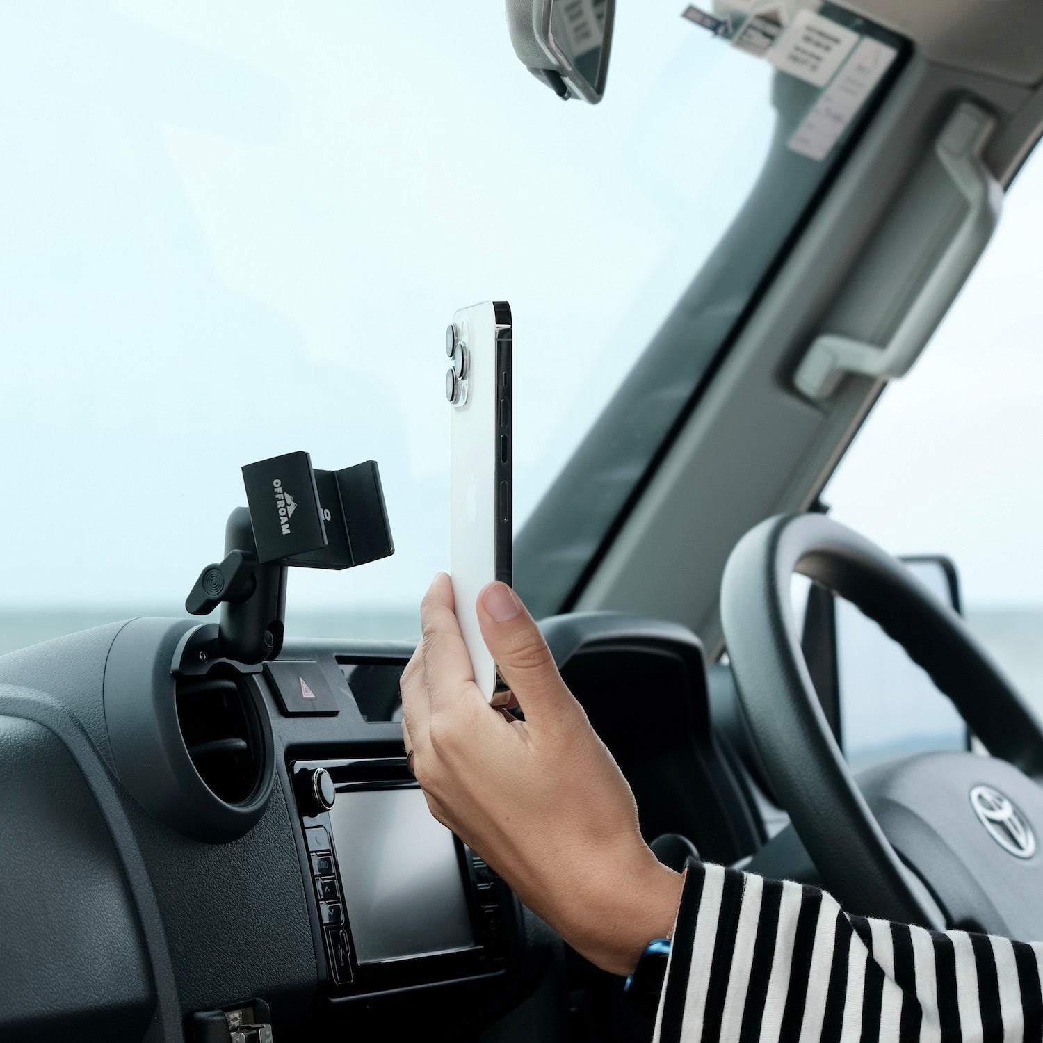Person using a smartphone with a car mount inside a vehicle