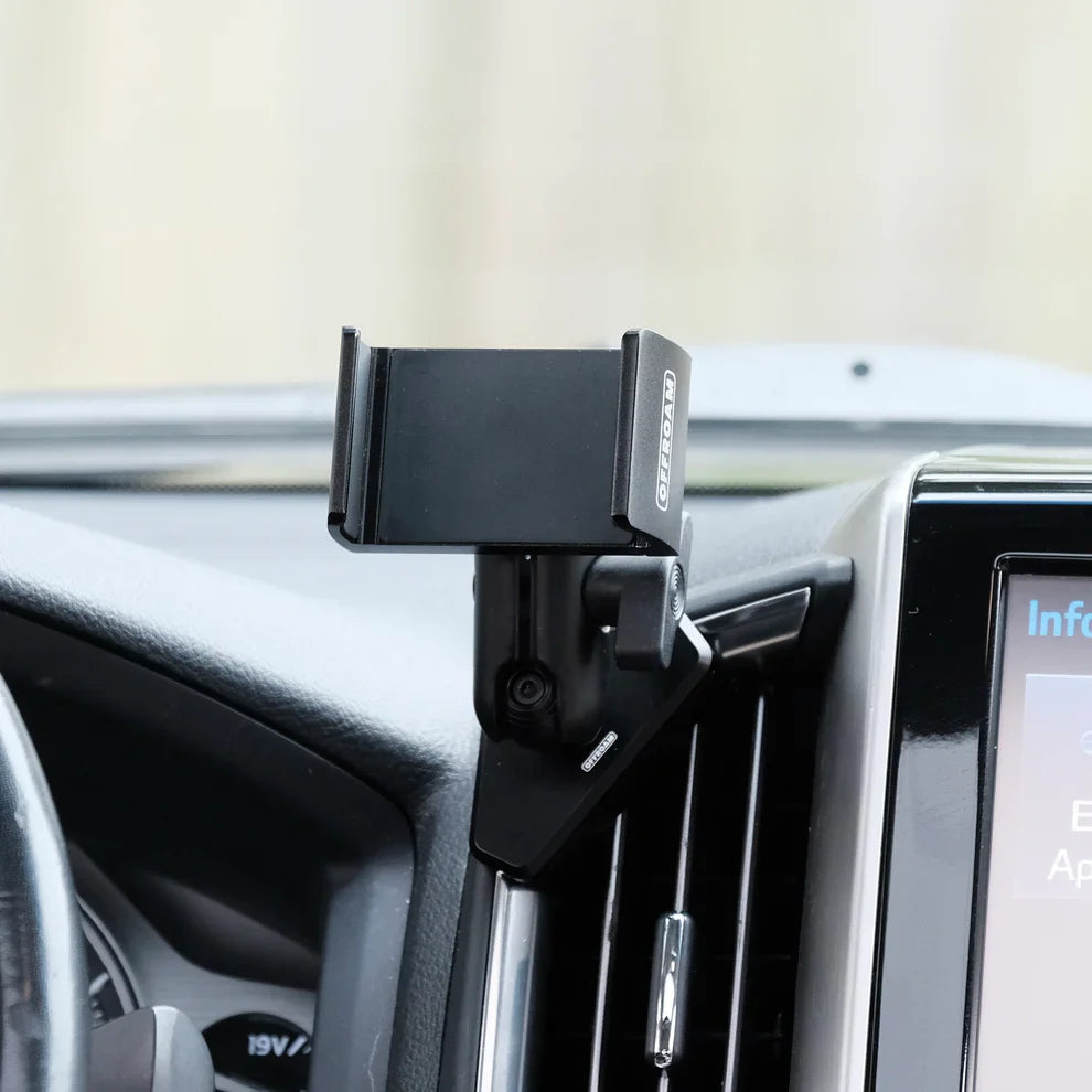 Car phone holder mounted on a car dashboard with a blurred background
