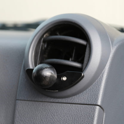 Car air vent with phone mount on a gray dashboard