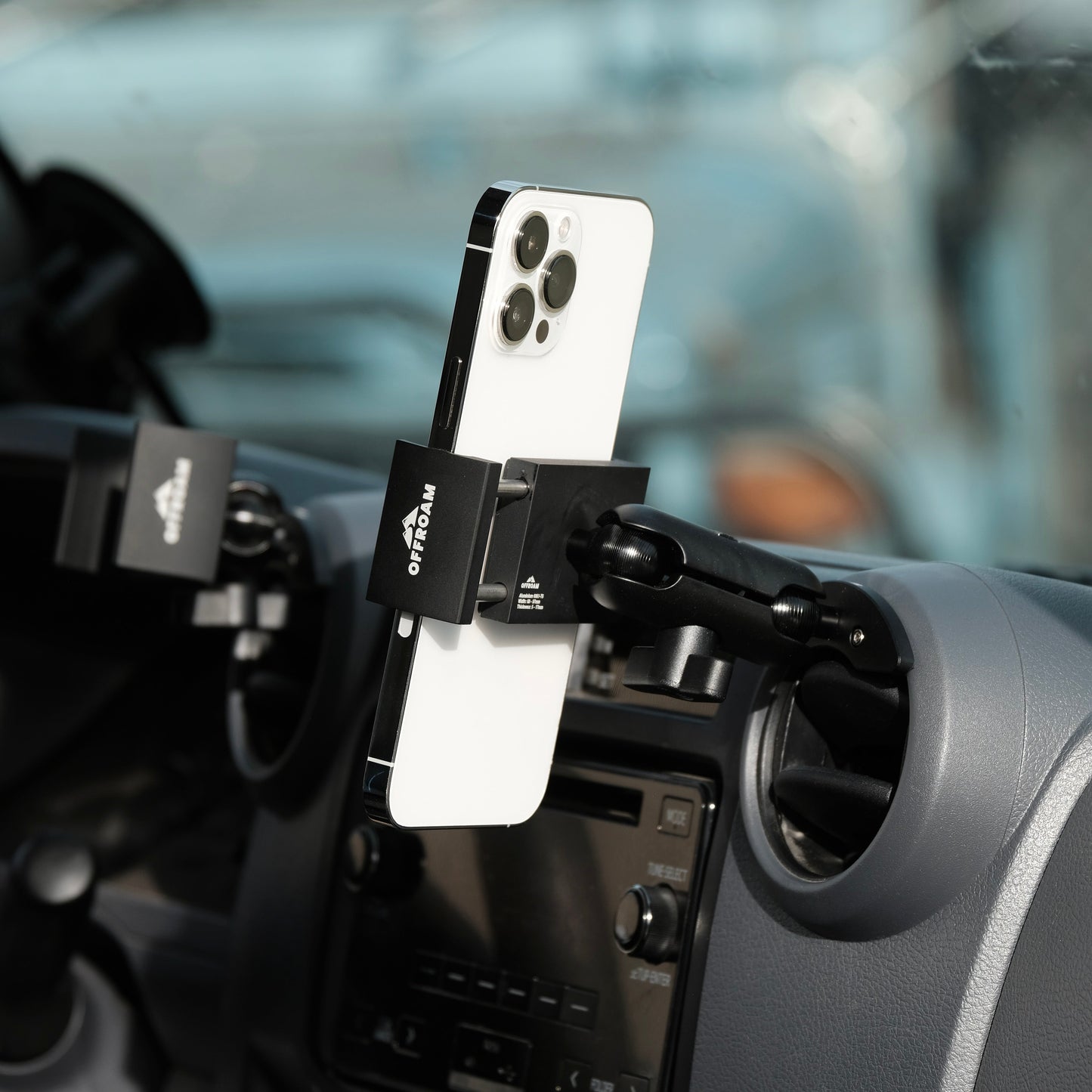 Phone holder with a smartphone attached, mounted on a car dashboard.