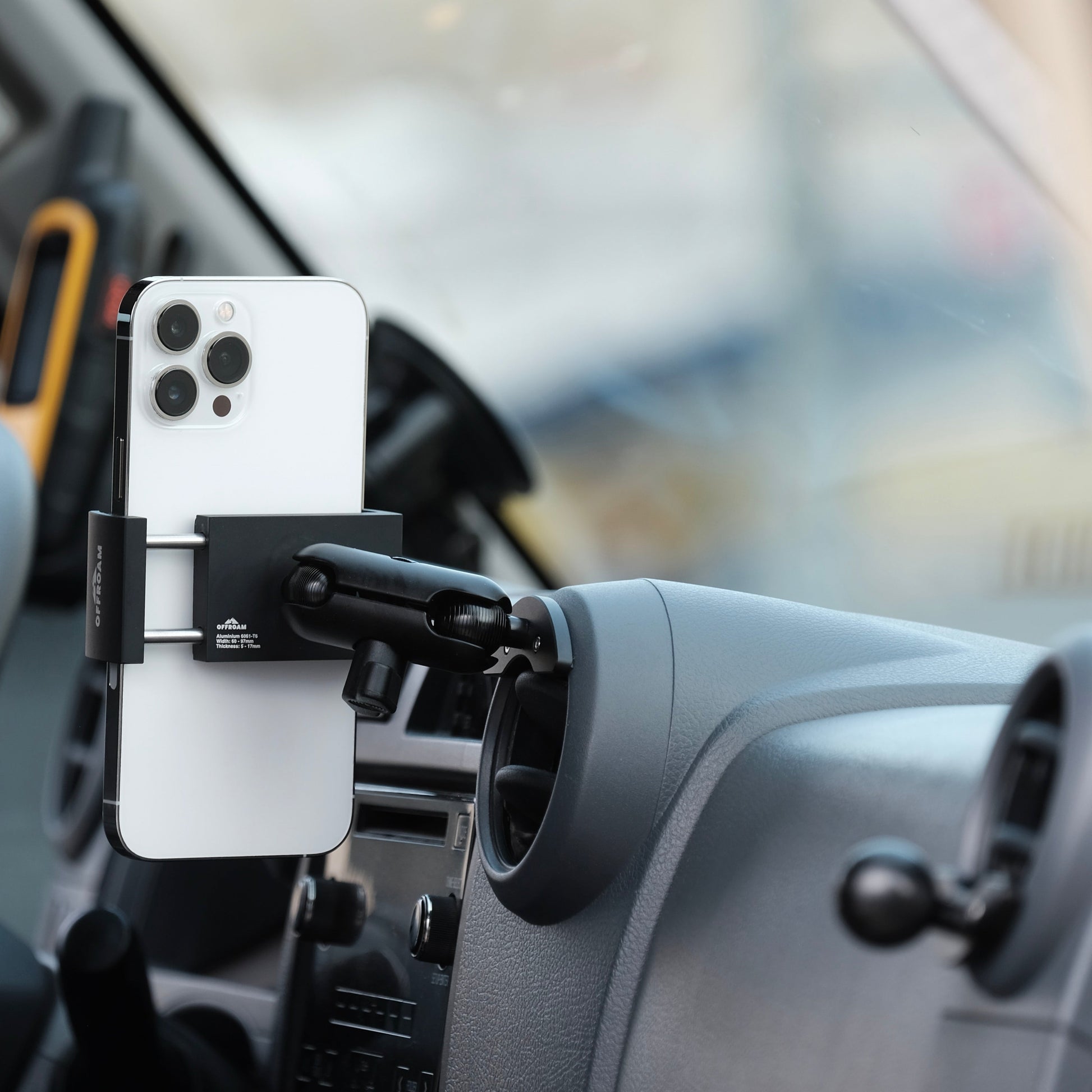 Phone holder attached to a car dashboard with a blurred background