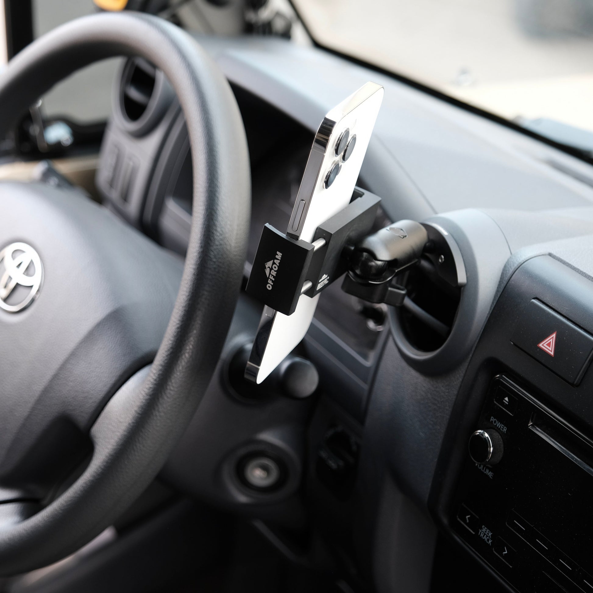 Phone holder attached to a car dashboard with a Toyota logo visible