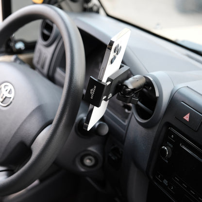 Phone holder attached to a car dashboard with a Toyota logo visible