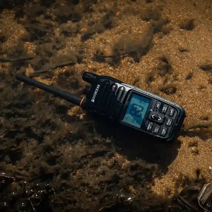 Black walkie-talkie on a wet sand background