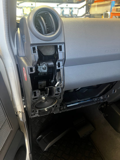 Car interior with open glove compartment and cup holders.