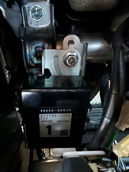 Close-up of a vehicle's electrical system with a Denso component.