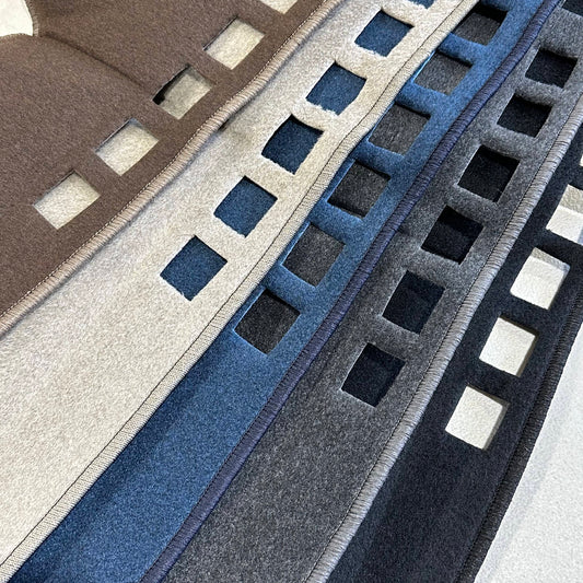 Close-up of mats in brown, gray, blue, and black.
