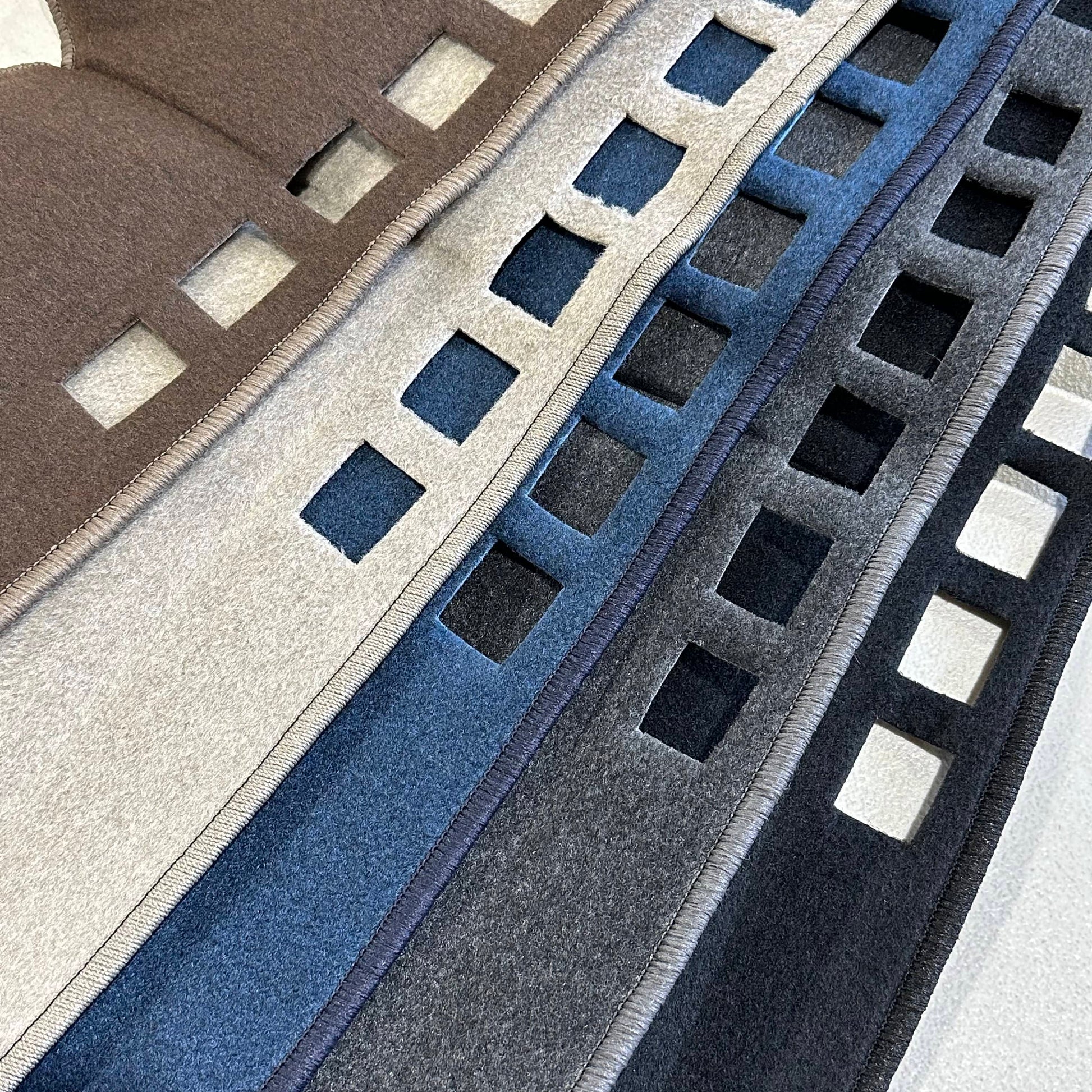 Close-up of dash mats in brown, gray, blue, and black.