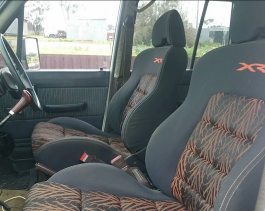 Car interior with patterned seat covers and visible branding