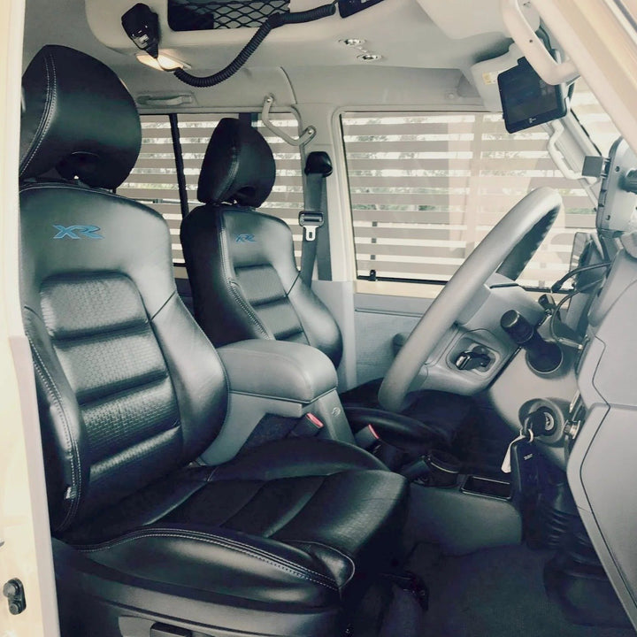 Interior of a vehicle with black leather seats and steering wheel.
