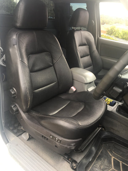 Black leather car seats inside a vehicle with a steering wheel visible.
