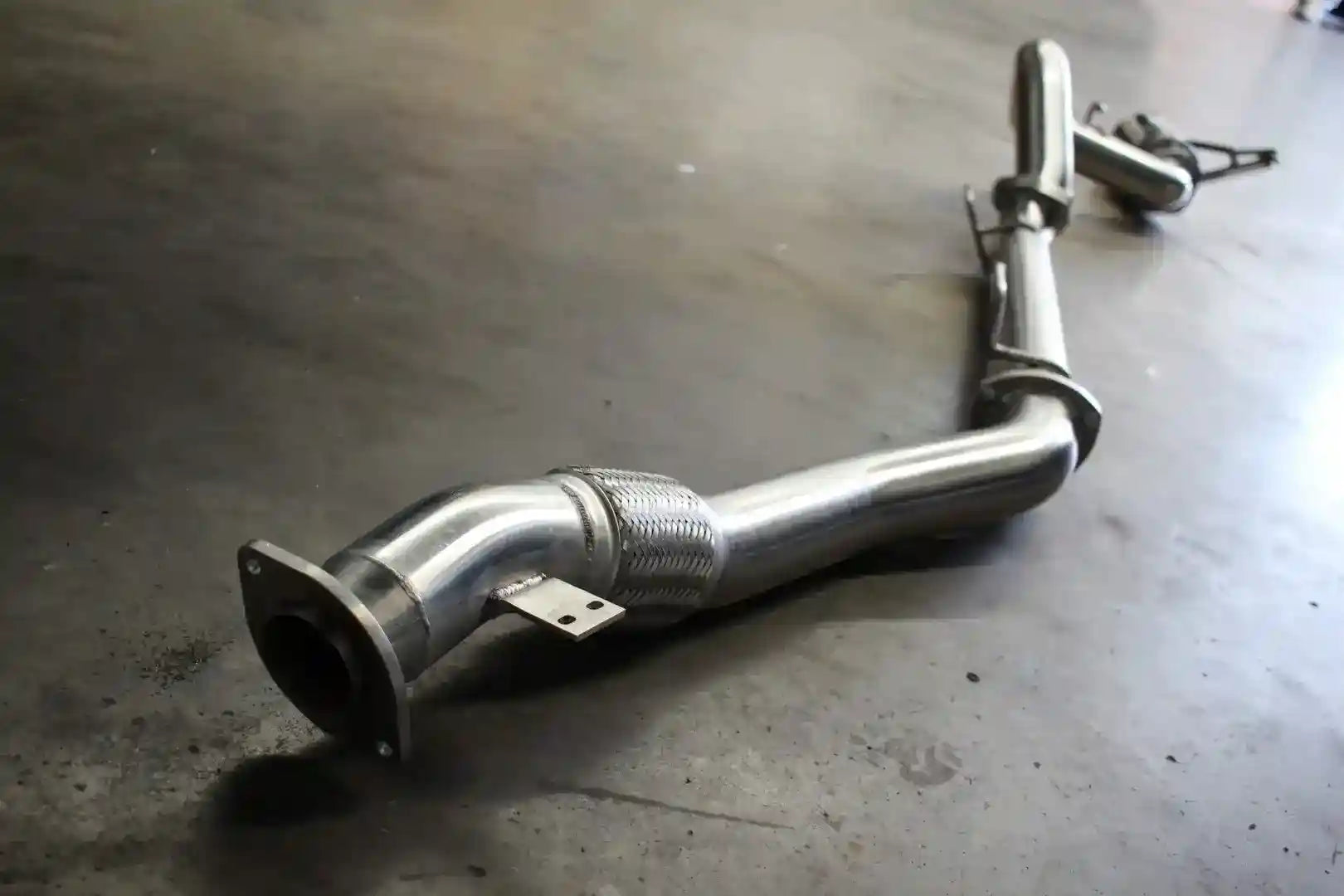 Metallic exhaust pipe on a concrete floor