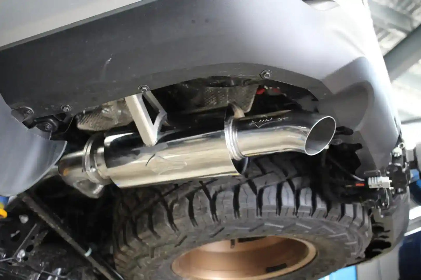 Close-up of a car exhaust system with a visible Beaudesert Exhaust logo.
