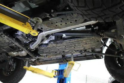 Close-up of a vehicle's undercarriage with suspension components and a wrench.