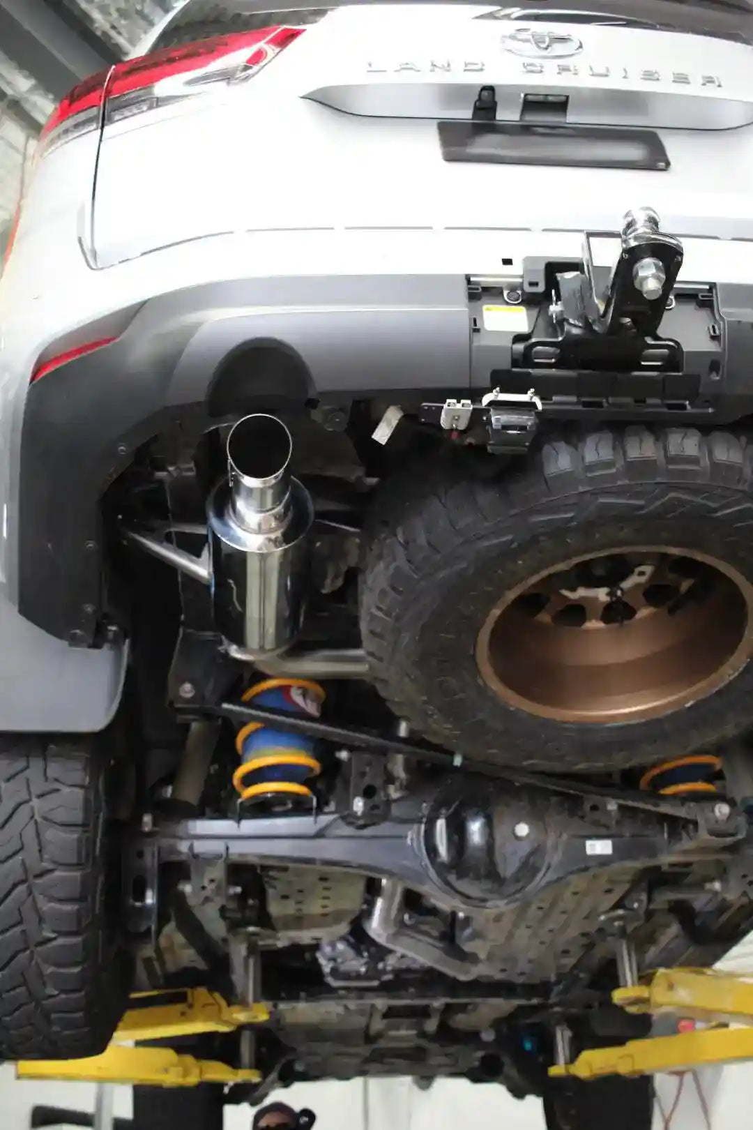 Close-up of a Land Cruiser vehicle with lifted suspension and off-road tires.