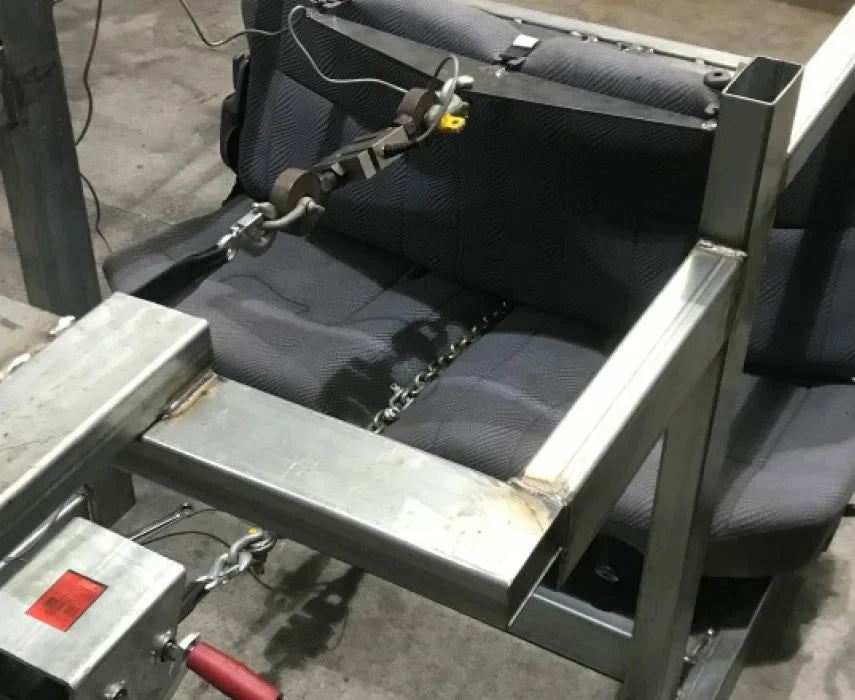 Mechanical device with a seat and chains on a concrete floor