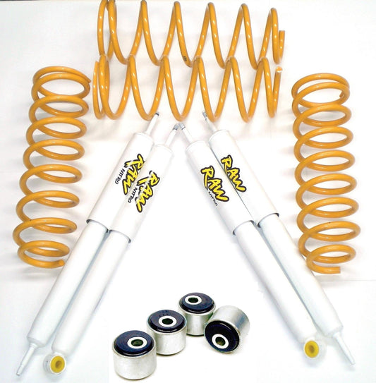 Two shock absorbers with yellow coils and mounting bushings on a white background