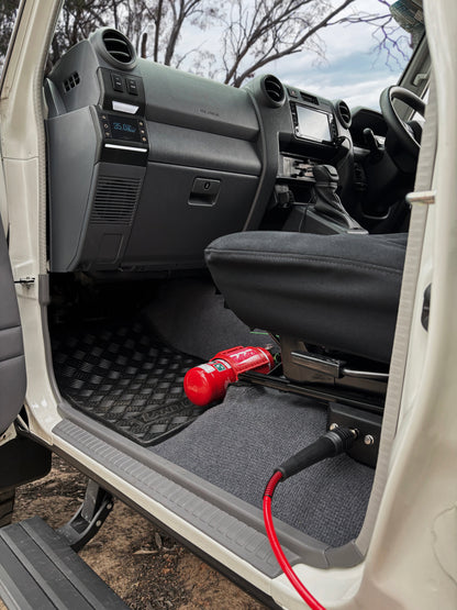 Car interior with a red fire extinguisher on a black mat and tire pressure system