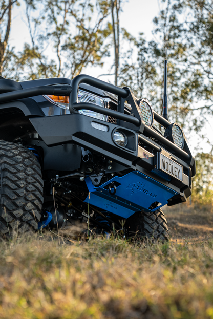 ATV with a blue front Radiator Protector in a forest setting