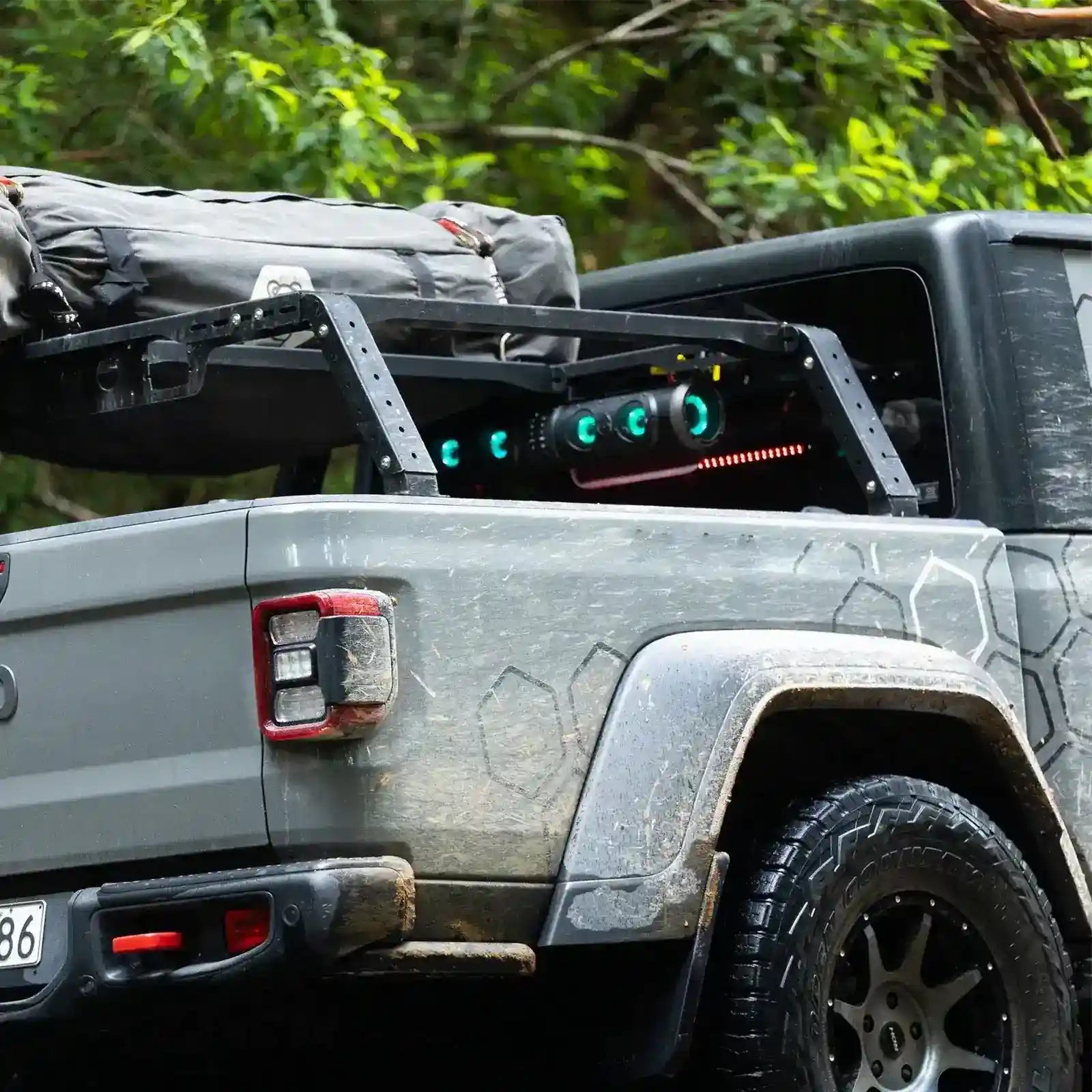 Gray off-road vehicle with mounted equipment and green lights in a forest setting
