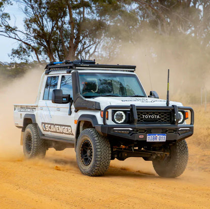 Toyota truck driving on a dirt road with dust in the air