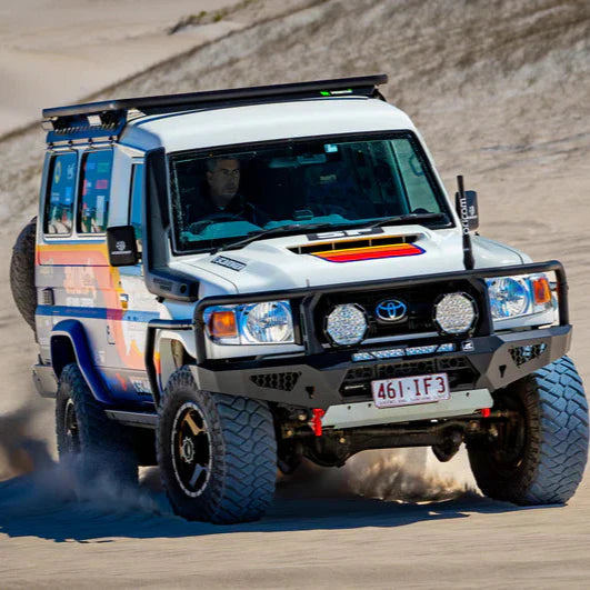 Toyota Land Cruiser on a dirt road with colorful design