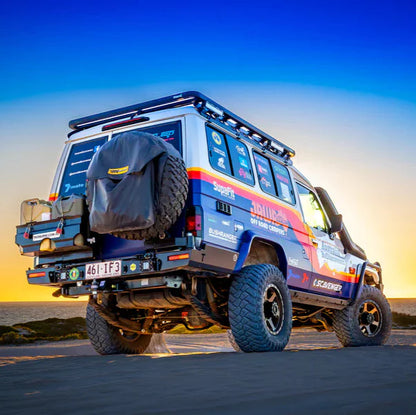 Off-road vehicle with colorful design on a beach at sunset