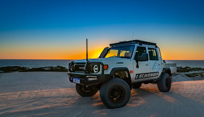 Off-road vehicle on a beach at sunset with 'Scavenger' branding.