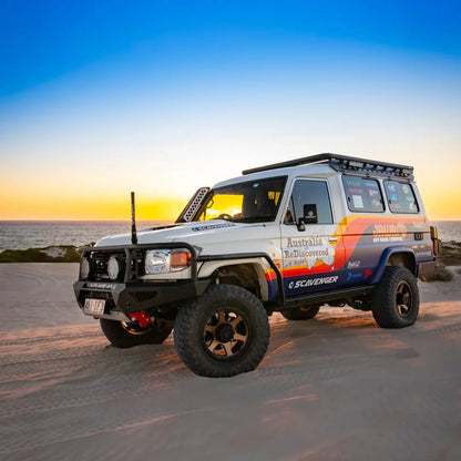 4x4 vehicle on a beach with sunset in the background
