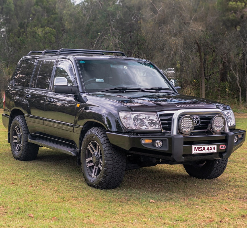 Black Toyota SUV with roof rack on grassy area