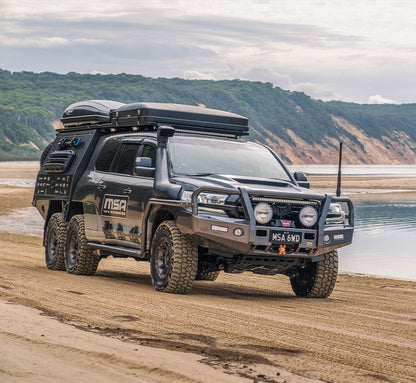 Off-road vehicle on a beach with mountains in the background