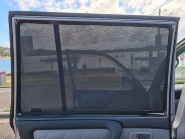 Car door with a screen and view of a road and buildings outside