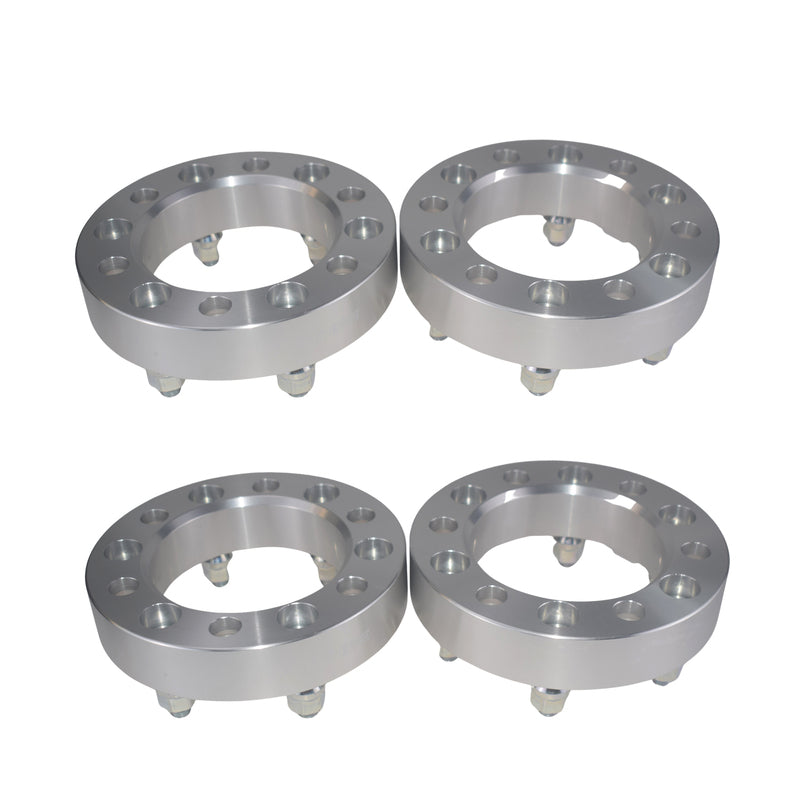 Four metallic wheel spacers on a white background