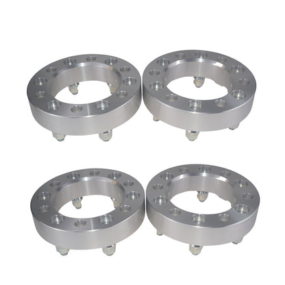 Four metallic wheel spacers on a white background