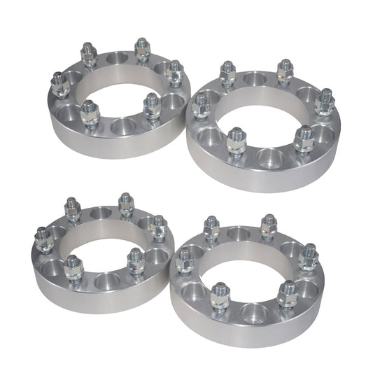 Four silver wheel spacers on a white background